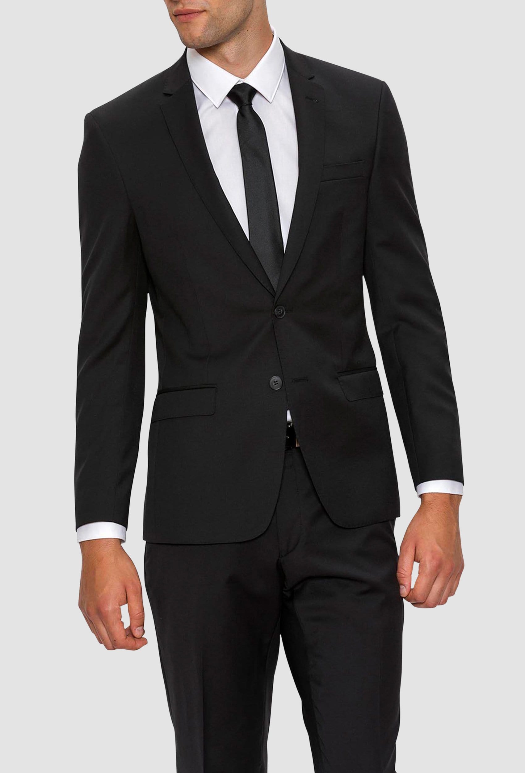 A model wears the Gibson slim fit lithium suit jacket in black pure wool F34087 styled with a white shirt