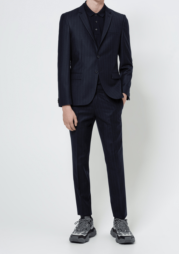 a model wears the hugo arti 204 suit from the hugo menswear collection, its a navy suit with a fine white pinstripe