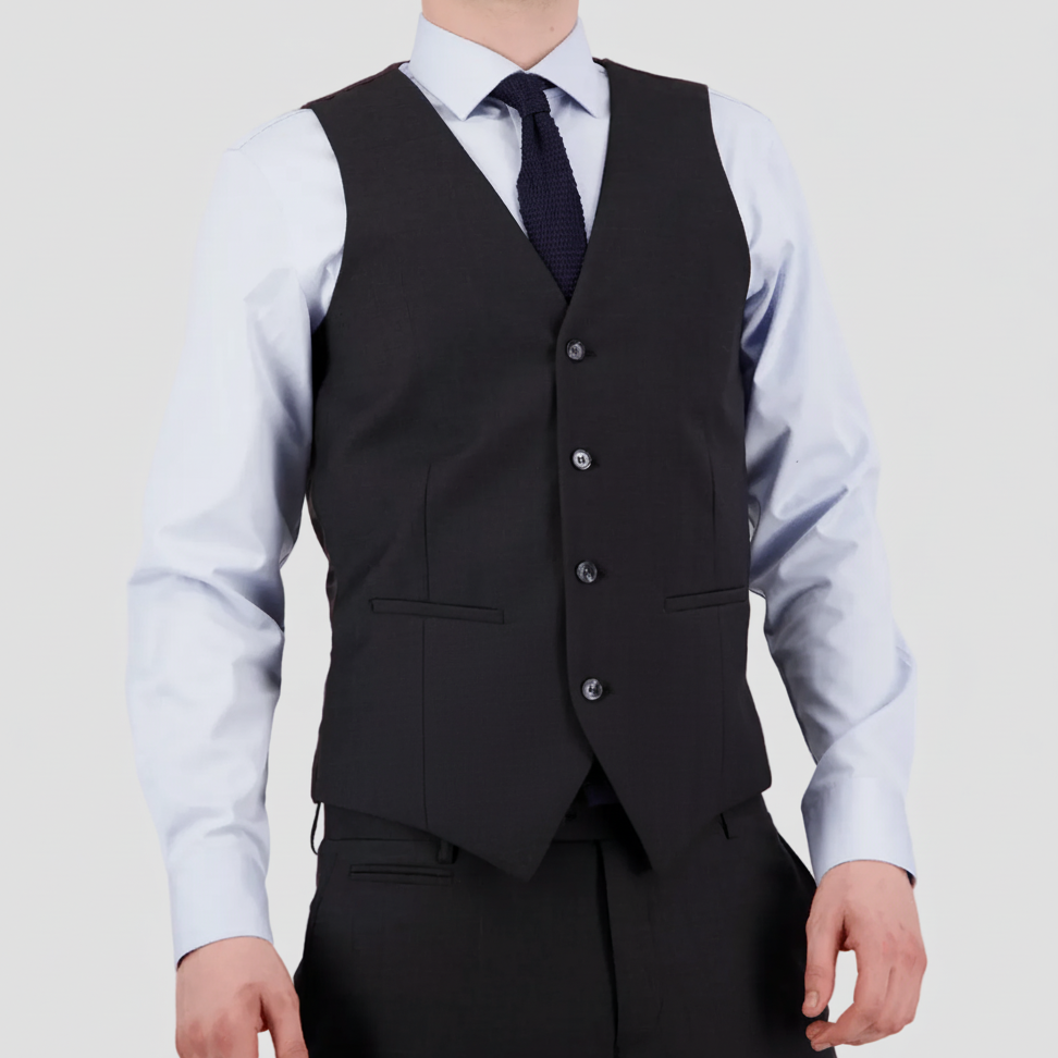 Tailored charcoal travel‑finish wool vest by Savile Row with matching dress pants, light blue shirt and navy tie.