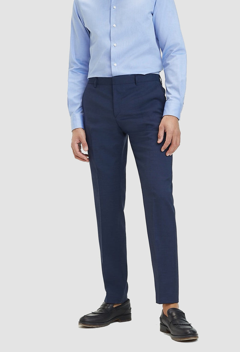 a model faces the front wearing the Tommy Hilfiger slim fit virgin wool trouser in navy blue styled with a light blue shirt