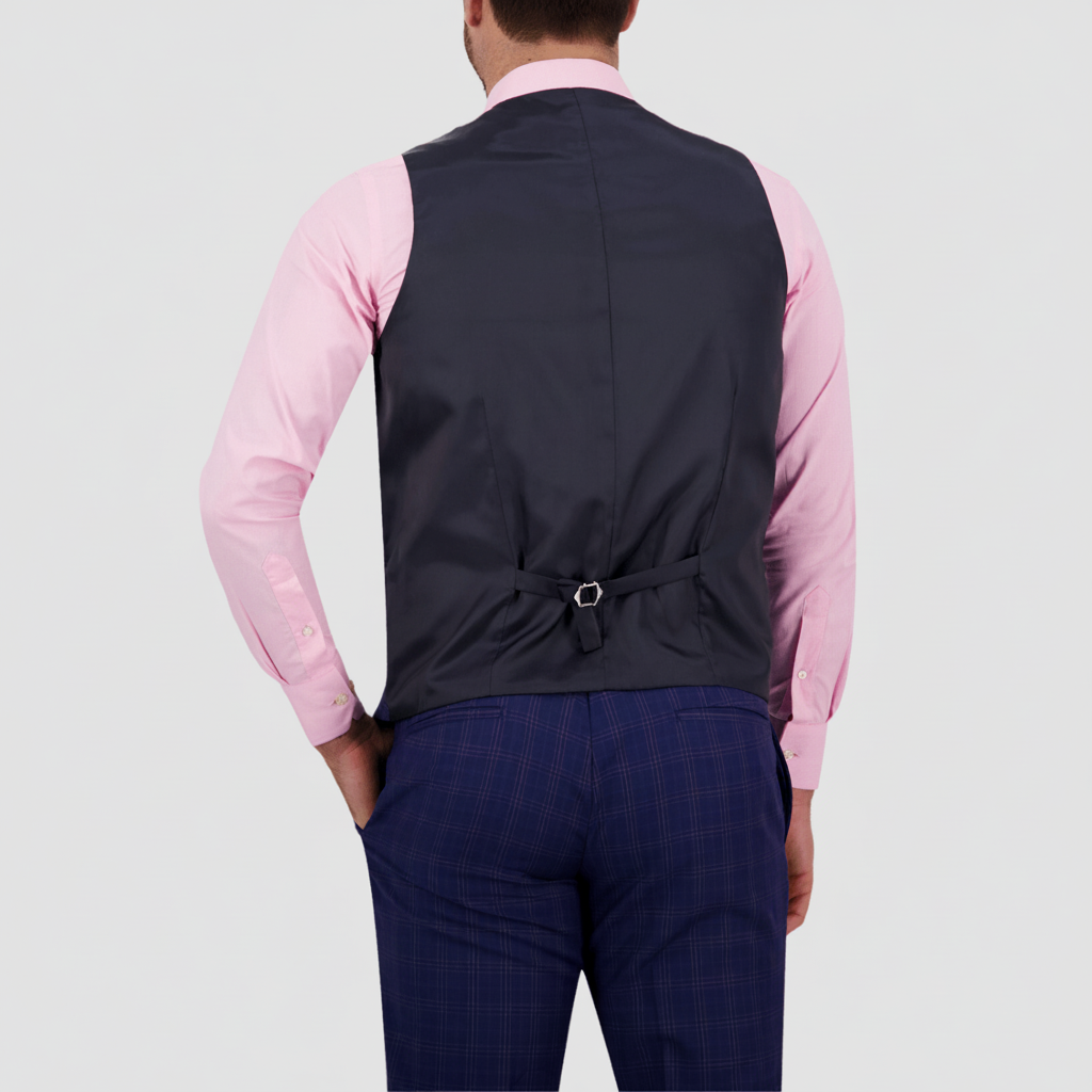 Azure blue patterned vest by Savile Row with a back tab adjuster over a pink shirt .