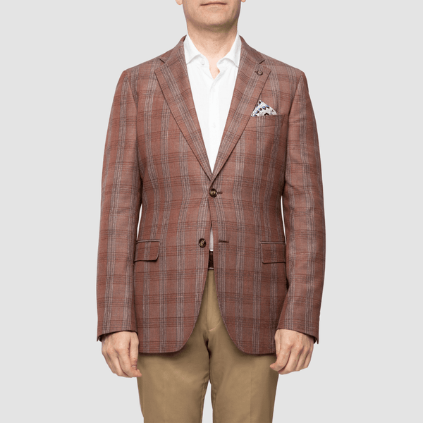 a man wears a red checked mens sports jacket over tan chinos and a white mens shirt