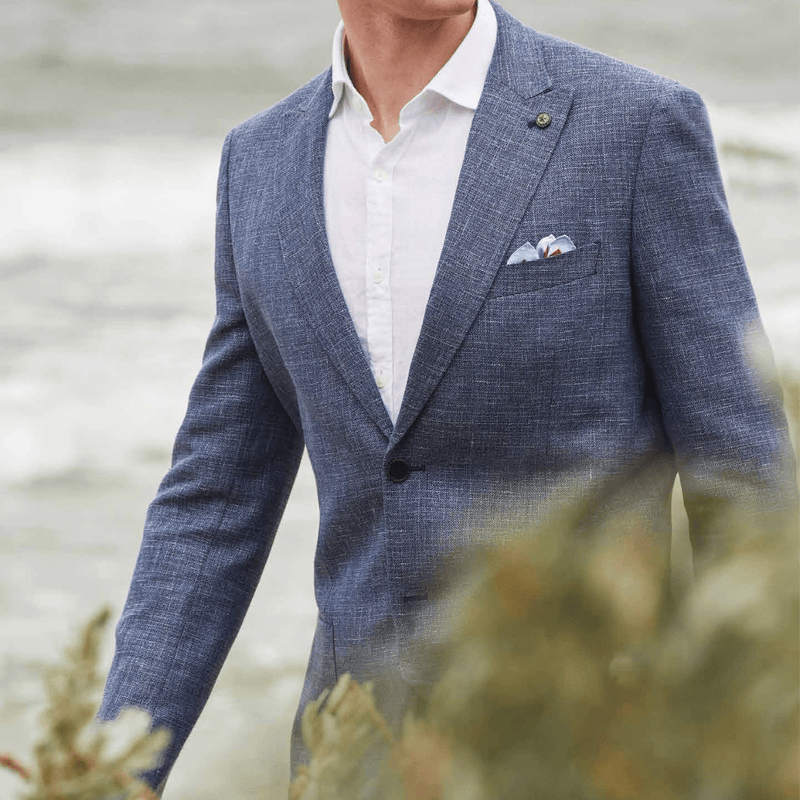 the riva linen shirt in white is worn under a blue textured sports jacket